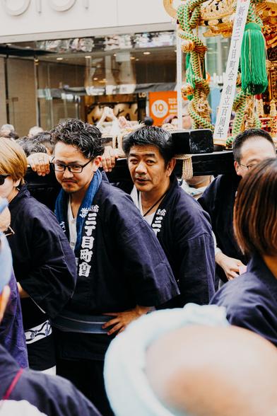 photo of some people in robe-like clothes carrying a a religious artifact on wooden planks