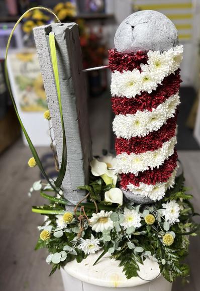 A 3D Barbers Pole created in fresh flowers, attached to a foliage wall.