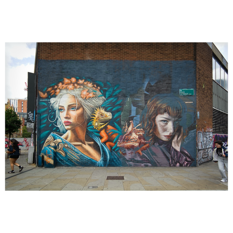 Street art of two female faces painted on a large brick wall at Old Street in London.