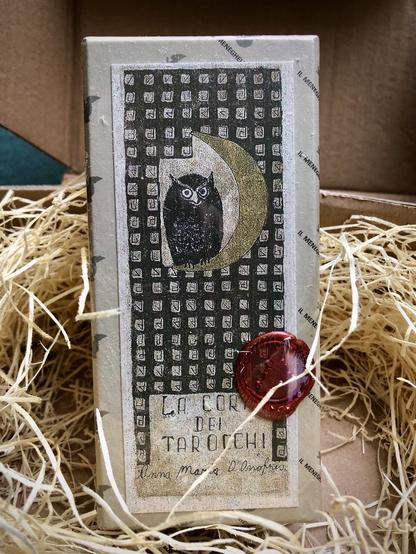Le boîtier de La corte dei tarocchi, scellé à la cire avec le sceau de l'éditeur El Meneghello.