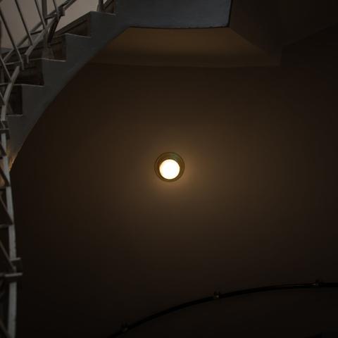 Photo of a light on the wall, in a staircase, inside a house in Prague