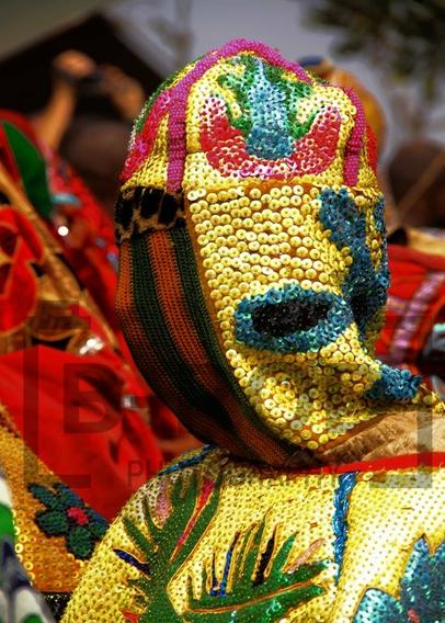 Photo of the head of an Egungun, a spirit in Yoruba tradition.

Fully masked, this particular costume is covered with small shiny flat beads, mostly yellow, red, green and blue.