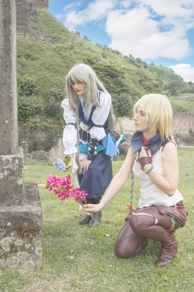 Grey haired woman placing flowers on a tomb
