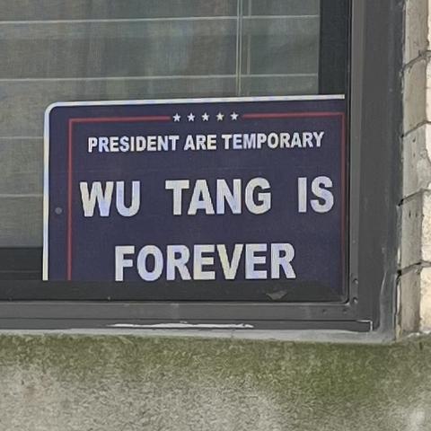 Photo of a sign in an apartment window. The text is "President are temporary. Wu Tang is Forever".
