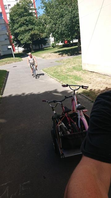 3 vélos enfants transportés à vélo dans un quartier ensoleillé.