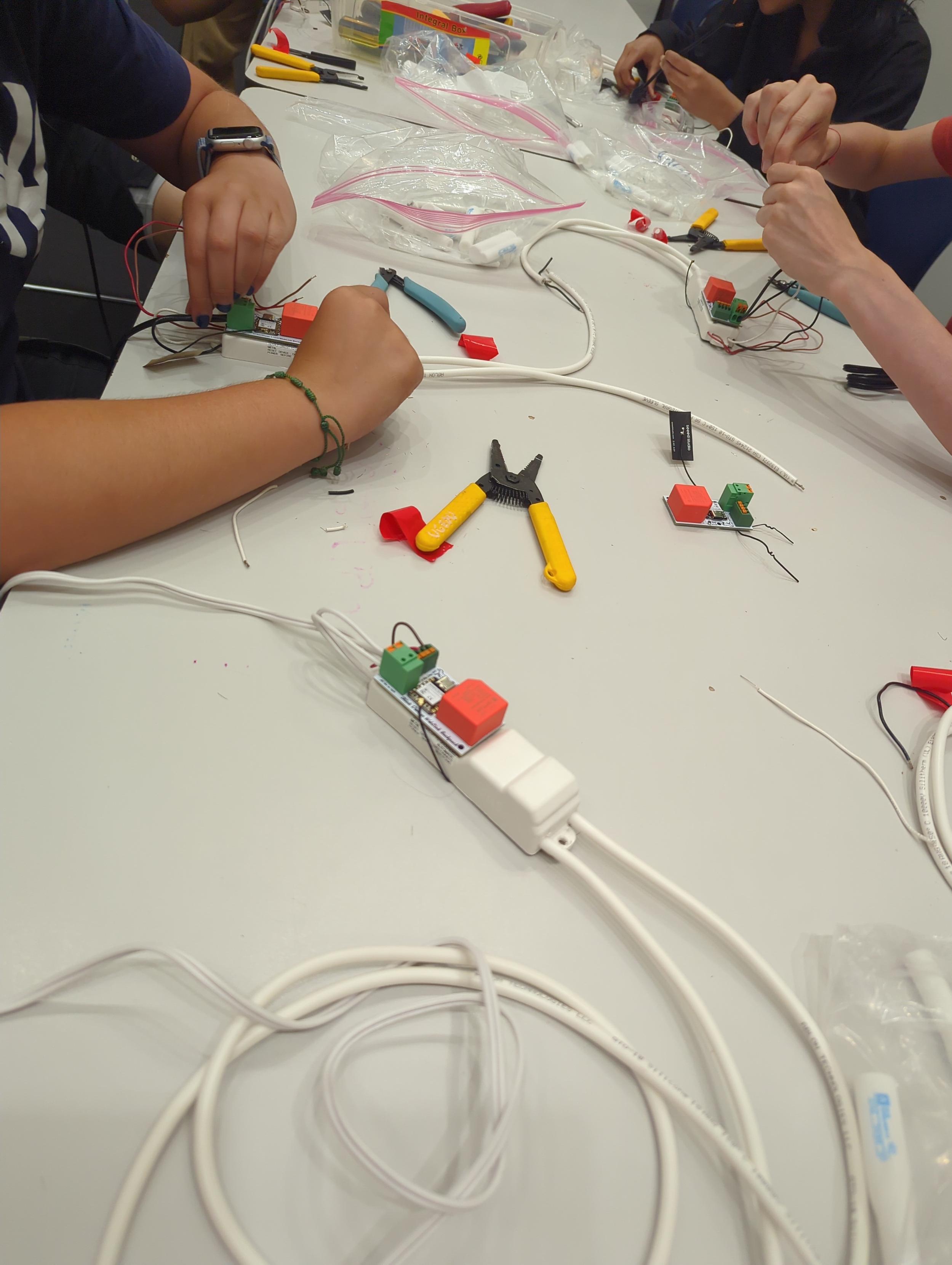 A table post soldering as students wire and tape their completer circuit board transformer WiFi backpacks to their transformers. Yes, we wired 120 VAC together