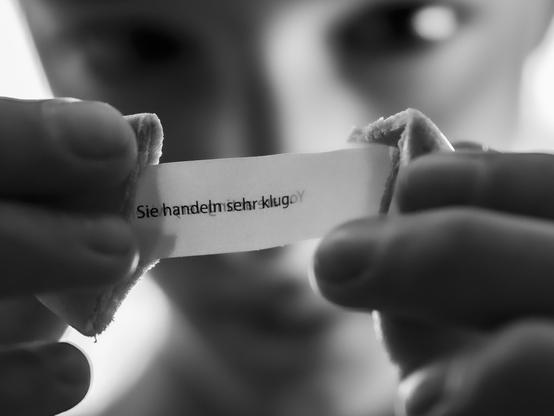 Black and white picture of a person opening a fortune cookies