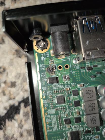 The 12V power input on a PCEngines APU. Just behind the power jack, there is a black burn mark one the PCB.