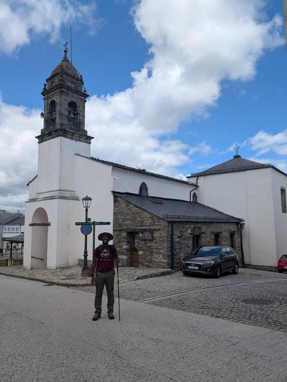 Me posing in front of a church wearing my hat and holding, looking like a pilgrim hehe