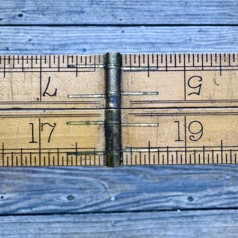 vintage folding brass and boxwood rule - showing two closed arms side by side, with the arm hinges and 5,7 upside down on the top and 17,19 inch marks on the bottom
