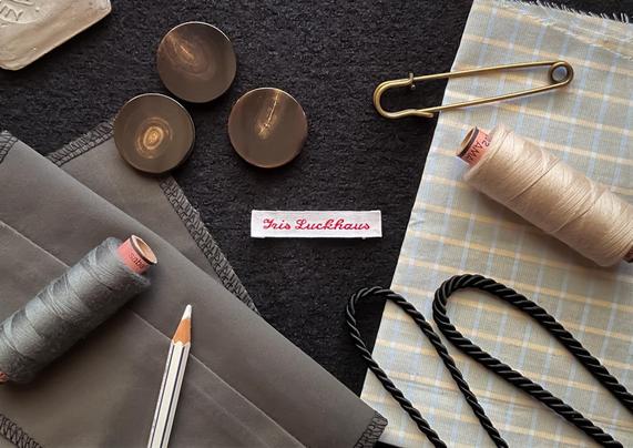 Foto von Kurzwaren und Etikett auf dem Zuschneidetisch von Iris Luckhaus