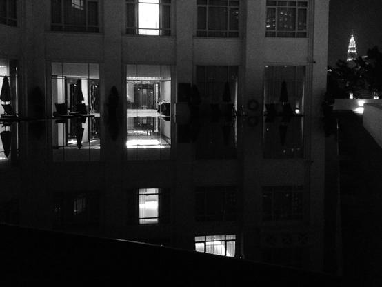 Petronas Towers at night, viewed from a swimming pool on a terrace. (Version françæ) Tour Petronas vux d’æn piscine en terrasse læ nuit.