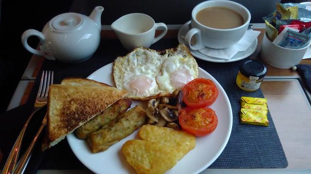 Train meal on proper crockery with teapot beside. Cooked breakfast with fried eggs, veggie sausage etc.