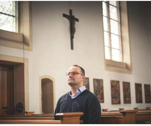 Jens Spahn, sitzt alleine, andächtig ,in einer Kirche !