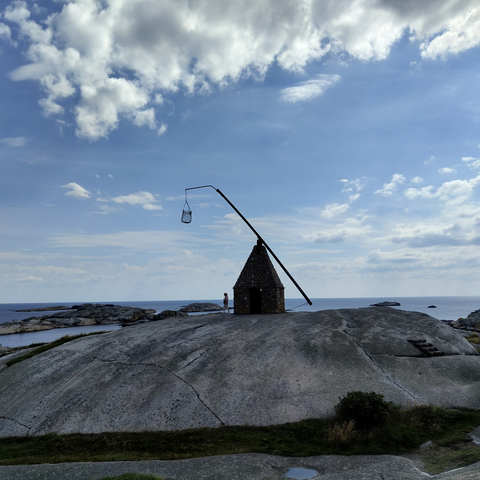 Das Modell eines Wippfeuers am Ende der Insel Tjøme, dem sogenannten Verdens Ende, mit Blick auf das Meer im Hintergrund.