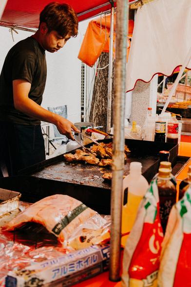 photo of a food vendor taking care of some grilled foods