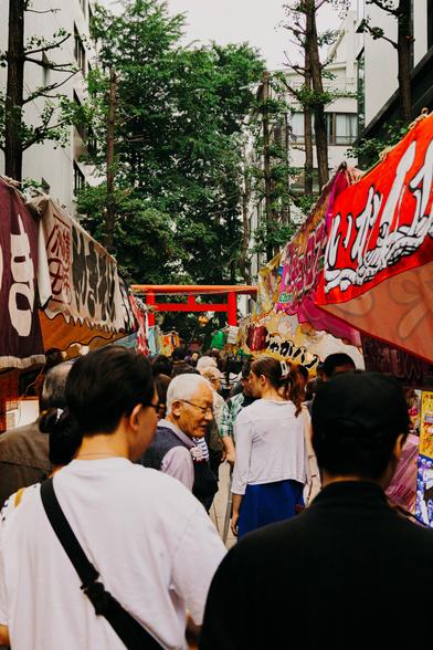 photo of a lot of people squeezing through a narrow alley with many food stands on each side