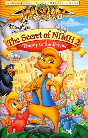 Movie cover of the movie.

The title reads in red letters on yellow banner "The Secret of NIMH 2" and in yellow on red "Timmy to the rescue".

Below it is Timmy, prominently displayed: a brownish-orange mouse boy wearing only a blue vest in a proud pose with his right fist in front of his chest.

Next to him is Jenny, a mouse girl in a res sweater with a thick blonde pony tail, seemingly cheering him on.

Shown additionally are Jeremy, a crow, and a green caterpillar with orange hair, blue west and hat and a red tie.

In the background you can see several stone or clay built houses and plenty of rodents seemingly cheering to Timmy as well.

On the very top, a big white cat is visible with an angry, aggressive expression, bearing its teeth and clawing into the movie's banner.
