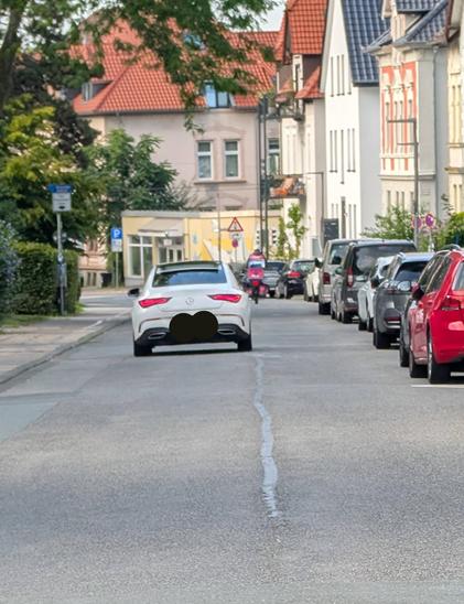 Ein weißer Mercedes auf einer Straße.