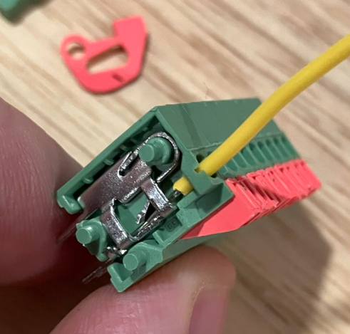 Partially-disassembled lever-wire connector with a wire installed to show where the wire seats against the contact