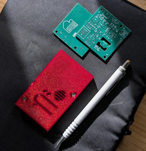 3D printed case in sparkly red filament and PCB. Mechanical pencil included for scale.