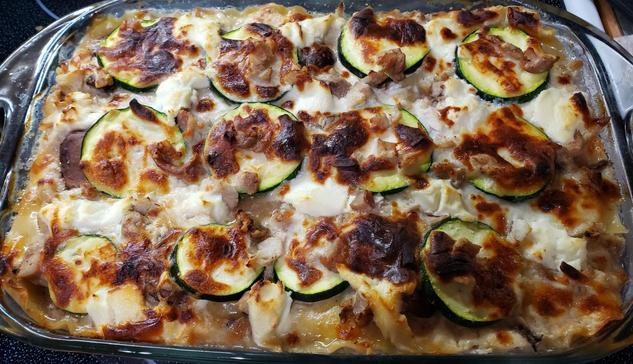 A white chicken lasagna with zucchini and mushrooms and the cheese broiled on top fresh out of the oven.