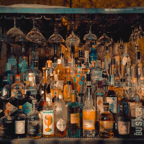 Numerose bottiglie di alcolici poste in ordine una vicina all'altra