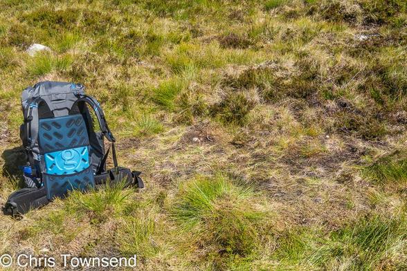 A rucksack on rough grassy ground.