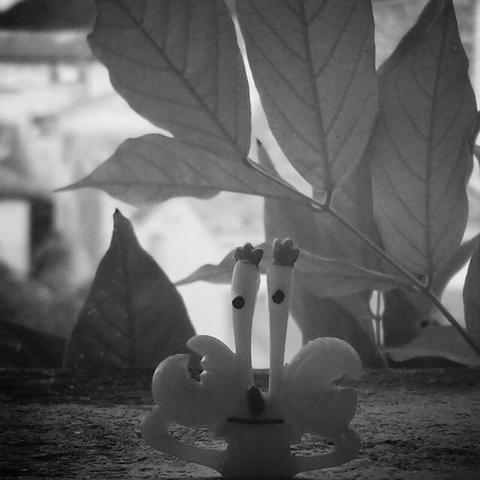 Crab-shaped toy on the edge of a balcony. (Version françæ) Jouet en forme de crabe posæ sur læ rebord d’æn balcon.