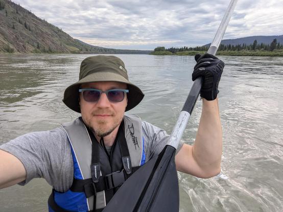 A selfie of me on a river holding up a paddle.