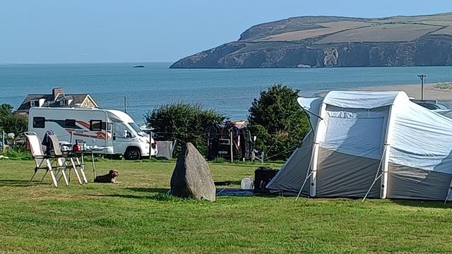 Vor uns auf dem Zeltplatz steht ein kleiner Standing Stone.
Kurz danach steht ein Zelt und Campungstühle und ein Hund liegt daneben