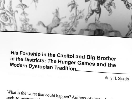 Pictured is the first page of an essay in the anthology Critical Insights: The Hunger Games Trilogy. The title of the essay, written by Amy H. Sturgis, is "His Fordship in the Capitol and Big Brother in the Districts: The Hunger Games and the Modern Dystopian Tradition."