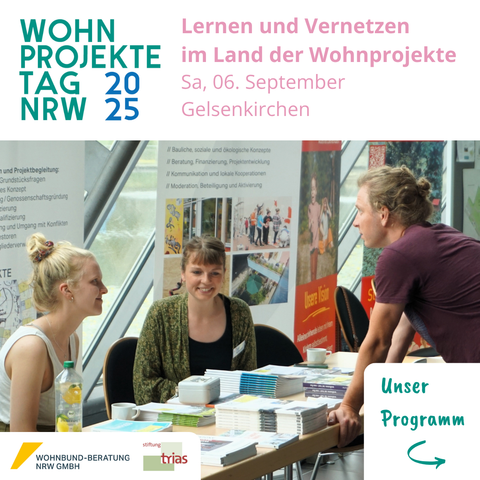 Das Bild zeigt eine Infostand mit ausgelegten Broschüren und Rollups im Hintergrund. Er wird besetzt von zwei freundlich blickenden, jungen weiblichen Menschen. Davor steht eine Person und blickt auf die Banner.