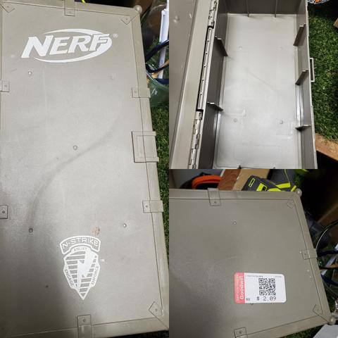 A Grey plastic box slightly larger than 2 shoe boxes branded Nerf N-strike meant to hold nerf darts and smaller blasters