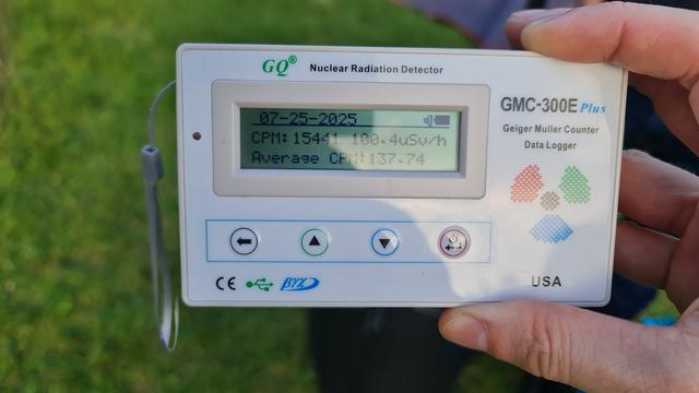 A small, portable Geiger Muller counter. The display shows a count of nearly 15,500 counts per minute, or around a hundred micro sieverts per hour.
