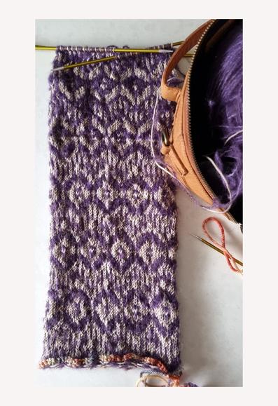 Knitted tube on 4 DPNs. Colour is stone and purple hand-dyed yarn. Stone is fingering, purple is mohair. Pattern is diamonds, lines, and zigzagged fair-isle.
The ends will be fastened together using Kitchener stitch to form a mobius cowl.