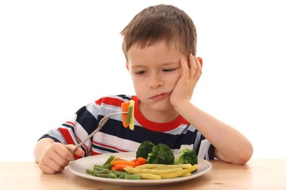 Un enfant qui refuse de manger ses légumes.