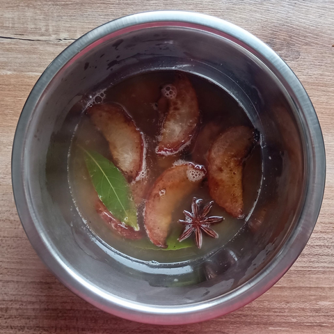 Eine kleine Schüssel mit den eingelegten Pfirsichspalten + Gewürzen