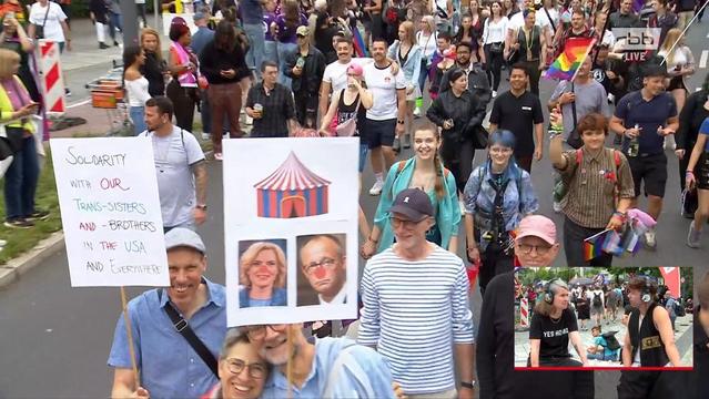 Plakat auf dem CSD mit Merz und Klöckner mit roten Nasen unter einem Zirkuszelt.