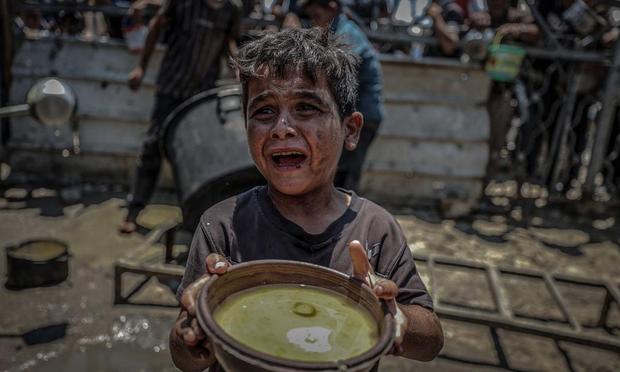 Una organización benéfica distribuye alimentos a palestinos que enfrentan graves dificultades para acceder a productos básicos debido al bloqueo y las operaciones militares de Israel en la Franja de Gazaç. (Ali Jadallah/Anadolu via Getty Images)
