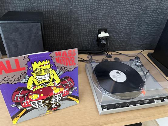 Picture of a record player and the album of Mass Nerder by All the punk band.