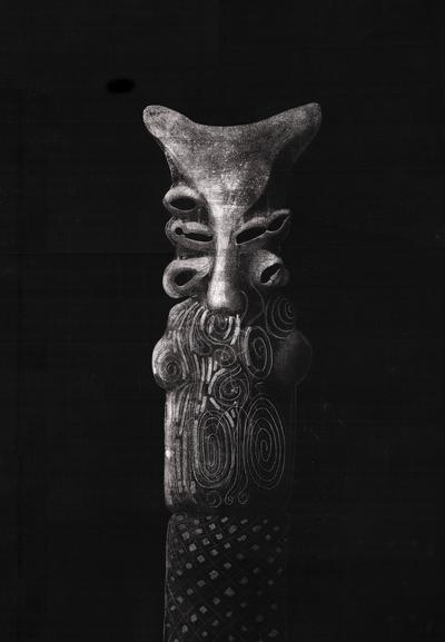 A black and white drawing of an ancient statue reminiscent of a strange creature with multiple mouths/eyes on a black background. Inspired by Sumerian demon statues.
