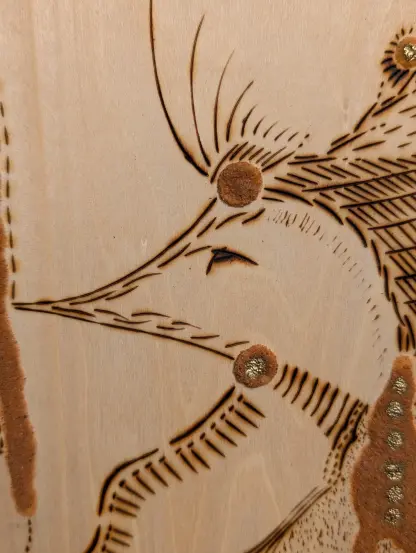 Détail d'un tableau en pyrogravure, tête d'une forma animal avec un regard tendre
