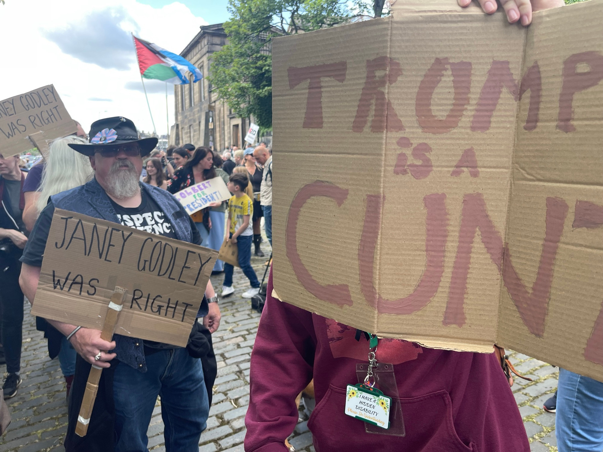 2 Scottish protestors holding signs. One says ' Janey Godley was right' The other says 'Trump is a cunt.'