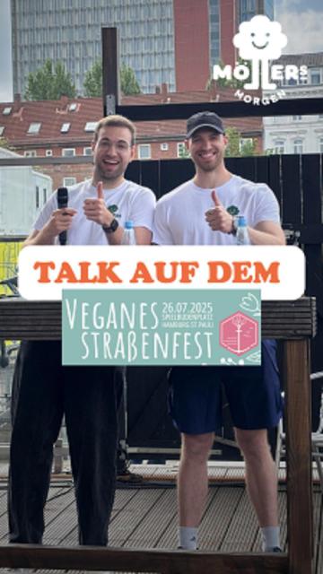 Das Bild zeigt zwei Personen, die auf einer Bühne stehen und in die Kamera lächeln. Beide tragen weiße T-Shirts und Shorts, und eine der Personen hält ein Mikrofon in der Hand. Über dem Bild ist ein Text mit der Aufschrift "Talk auf dem" zu sehen, was darauf hindeutet, dass sie einen Vortrag oder eine Präsentation halten. Vor ihnen ist ein Schild mit der Aufschrift "Veganes Straßenfest" und dem Datum "26.07.2025" zu sehen, was darauf hinweist, dass das Event das vegane Straßenfest ist, das am 26. Juli 2025 stattfindet. Das Logo "Möllers Morgen" ist in der oberen rechten Ecke des Bildes sichtbar, was darauf hinweist, dass die Personen mit diesem Betrieb verbunden sind.