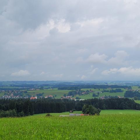 Grüne Wiese, Wald und Dörfer. Sehr grauer Himmel