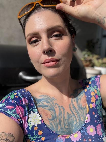 A selfie of Wanda, a 36 year old nonbinary person, showing off their makeup in the warm sun.