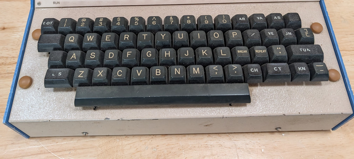 A retro keyboard (not dissimilar to an Apple II keyboard) with "CH' "CT" "KN" "TUN" and "LOT" keys in addition to a somewhat standard keyboard layout.