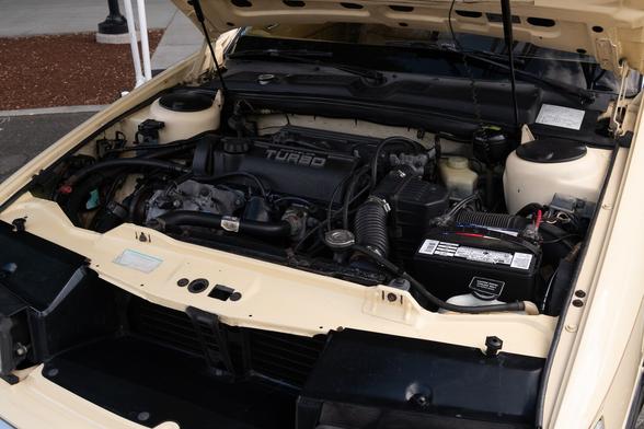 A peek inside the engine compartment. A smallish engine block sits toward the passenger side, looking a little tiny in the spacious engine bay. The word “TURBO” is proudly written on the engine cover.