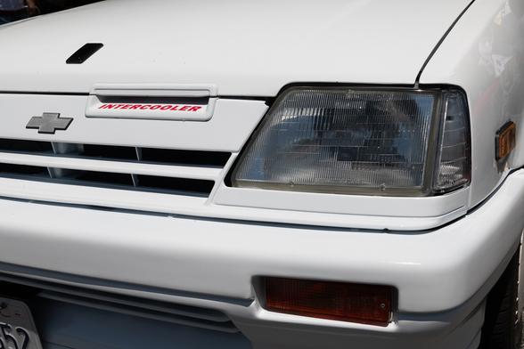 Front end close up of a white hot hatch. A small opening in the grille reads INTERCOOLER.